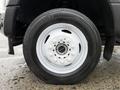 Close-up of a white wheel on a 2022 Ford F-550 featuring a circular rim with multiple bolts and a black tire with clear tread design
