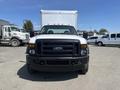 A white 2008 Ford F-450 Super Duty truck facing the camera with a black front grille and orange lights on the roof