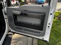 Interior door panel of a 2016 Ford F-550 featuring a gray handle a storage pocket and textured accents