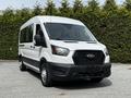 A white 2022 Ford Transit van facing slightly to the left with a large windshield and a black grille prominent in the front