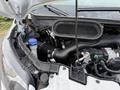 A 2022 Ford Transit with its hood open showing the engine compartment including various components like the air intake and a blue cap reservoir