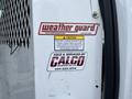 A 2008 Ford Econoline with a weather guard decal and service information label on the vehicle's door