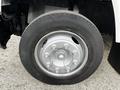 Close-up of a silver wheel on a 2006 GMC C5000 featuring a black tire with prominent tread and multiple lug nuts visible on the rim