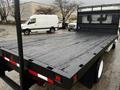 A 2006 Hino 155 flatbed truck with a wooden deck and black metal rails visible in the foreground