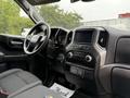 Interior of a 2022 GMC Sierra 1500 featuring a black dashboard a touchscreen display and climate controls visible on the center console and driver seat with fabric upholstery