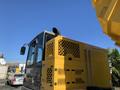 A 2022 TerraMac Tracked Dump with a yellow and gray body featuring ventilation grates and an exhaust pipe visible on the side