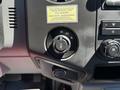 Close-up of a 2014 Ford F-250 SD control panel featuring knobs for adjusting drive modes and controls for air conditioning and other vehicle functions