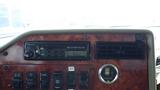 Dashboard of a 2003 International 5600i featuring a Panasonic weather band radio controls and various switches for panel and accessory functions