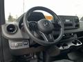 Interior view of a 2021 Mercedes-Benz Sprinter showcasing the steering wheel dashboard and control panel with storage compartments