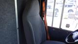 A gray fabric driver's seat from a 2011 Ford Econoline with a wooden armrest and an unobstructed view of the vehicle's interior