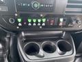 The interior control panel of a 2017 Chevrolet Express featuring various buttons and switches along with a cup holder section