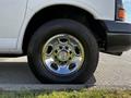 A close-up of a chrome wheel with a Chevrolet logo on a 2015 Chevrolet Express van's tire