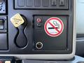 Interior dashboard controls of a 2010 International 4300 featuring a parking brake lever and a no smoking sign