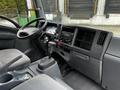 Interior of a 2018 Isuzu NPR featuring a driver's seat steering wheel dashboard gear shift and controls