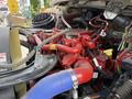 Close-up of the red engine components of a 2020 Freightliner M2 featuring various hoses and electrical connections