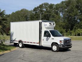 A white 2019 Ford Econoline box truck with a refrigerated unit on top facing slightly to the right