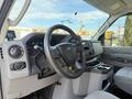 A 2023 Ford E-450 interior with a steering wheel and dashboard featuring gauges and controls
