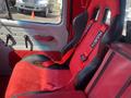 Interior of a 1962 Ford F-100 featuring red and black racing seats with harnesses and a modern design