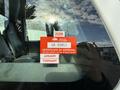 A 2011 International 4300 with a red certificate of approval sticker affixed to the window stating it is valid until the last day of February 2026