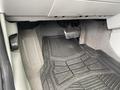 The interior of a 2007 Chrysler PT Cruiser showing the footwell with a rubber floor mat the brake pedal and the accelerator pedal