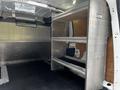 Interior of a 2014 Ford Transit Connect showing metal shelving units installed along one side of the cargo area
