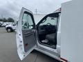 A white 2003 Ford F-450 SD with an open driver's side door showcasing the interior features and seating