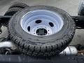 A spare tire mounted on a silver wheel positioned on the chassis of a 2024 Ford F-550