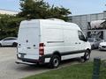 A 2012 Mercedes-Benz Sprinter van in white with a high roof and rear doors open, displaying a spacious cargo area