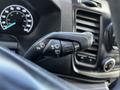 A close-up view of the control stalk inside a 2021 Ford Transit featuring buttons for windshield wipers and headlights