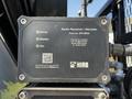 A black radio receiver decoder device with a QR code and technical details, labeled with error and radio indicators, mounted on equipment of a vehicle