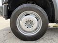 Close-up of a silver wheel with a circular design and six bolts from a 2008 Ford F-550 showing a tire with the tread pattern visible