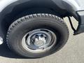 A close-up view of the wheel and tire of a 2007 Chevrolet Express featuring a silver wheel with a Chevrolet logo and a rugged tire tread