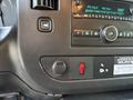 Dashboard controls of a 2015 GMC Savana featuring a radio display and buttons for audio settings