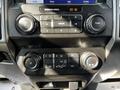 The image shows the dashboard controls of a 2021 Ford F-550 featuring buttons for audio and climate settings