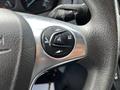 Close-up of a steering wheel control panel featuring buttons for audio volume and voice command on a 2018 Ford Transit
