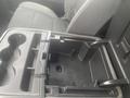 A black center console with cup holders and storage compartment in a 2015 Chevrolet Silverado 3500HD