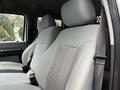 Two gray fabric bucket seats of a 2014 Ford F-550 with adjustable headrests and seatbelts