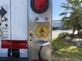 A yellow lever labeled Up and Down is mounted on a metal panel of a 2015 Freightliner M2 106 truck