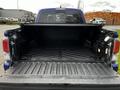 The image shows the open bed of a 2022 Toyota Tacoma with a textured black liner and no cargo inside