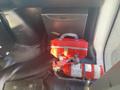 A red backpack and a fire extinguisher are placed on the floor of a 2018 Chevrolet Express