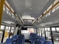 Interior view of a 2018 Chevrolet Express bus showcasing blue passenger seats and overhead storage compartments