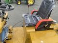 2024 AGT KRW 23 Mini loader featuring a black seat with red armrests wrapped in plastic and a steering wheel with controls visible