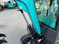 A 2024 AGT Industrial Green QH13R Mini Excavator showcasing its hydraulic arm and track details