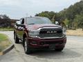 A 2024 RAM 3500 pickup truck in a deep red color with a chrome grille and prominent RAM logo on the front
