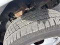 Close-up of a tire from a 2018 Chevrolet Express featuring worn tread patterns and visible dirt accumulation