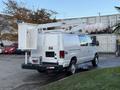 A white 2007 Ford Econoline van equipped with an elevated bucket and utility platform on top for maintenance or installation tasks