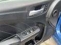Interior door panel of a 2022 Dodge Charger featuring a speaker vent and controls for power windows and locks