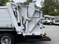 A 2014 Hino 195 garbage truck with a white and gray color scheme featuring a hydraulic lift system and compartment for waste collection