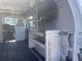 Interior of a 2009 Ford Econoline van featuring metal shelving and storage compartments with a spacious cargo area