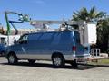 A blue 2008 Ford E-350 utility van with a raised crane mechanism on top and a storage compartment attached to the rear